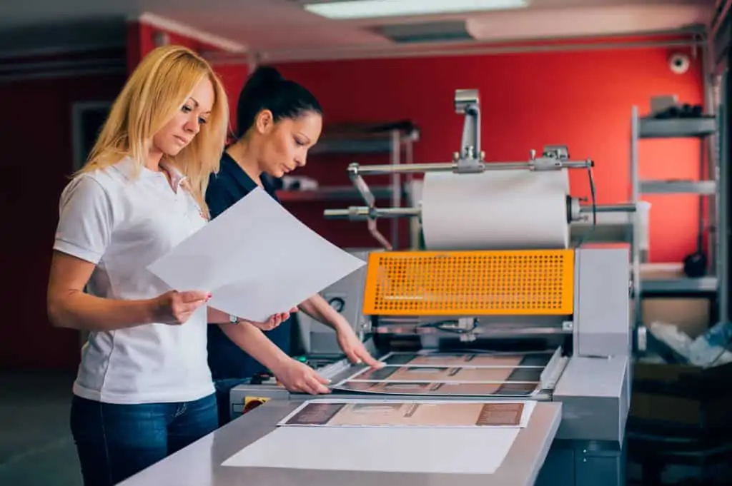 Women Work At A Printing Machine